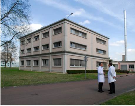 Two researchers stand outside Eurisotop headquarters